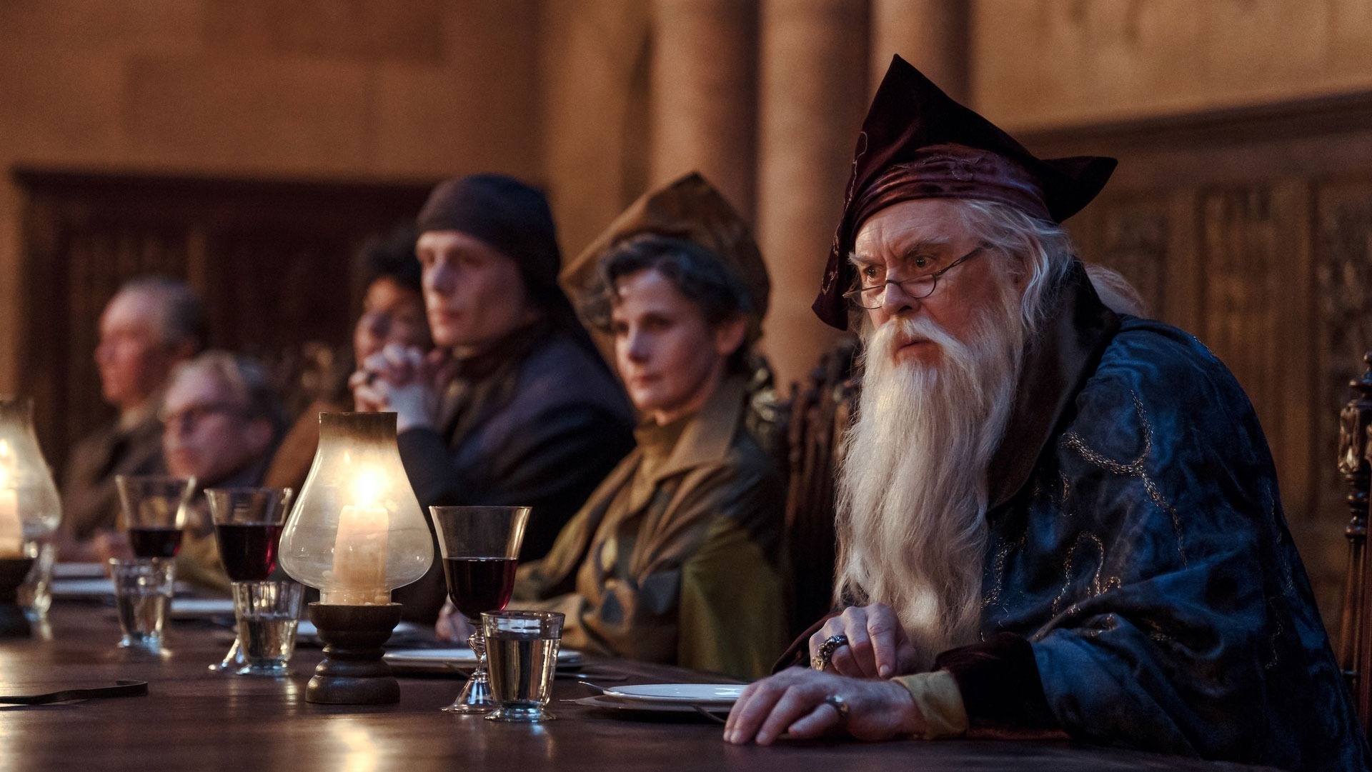 John Lithgow en Albus Dumbledore à la table des professeurs de Poudlard, aux côtés de Luke Thallon en professeur Quirrell